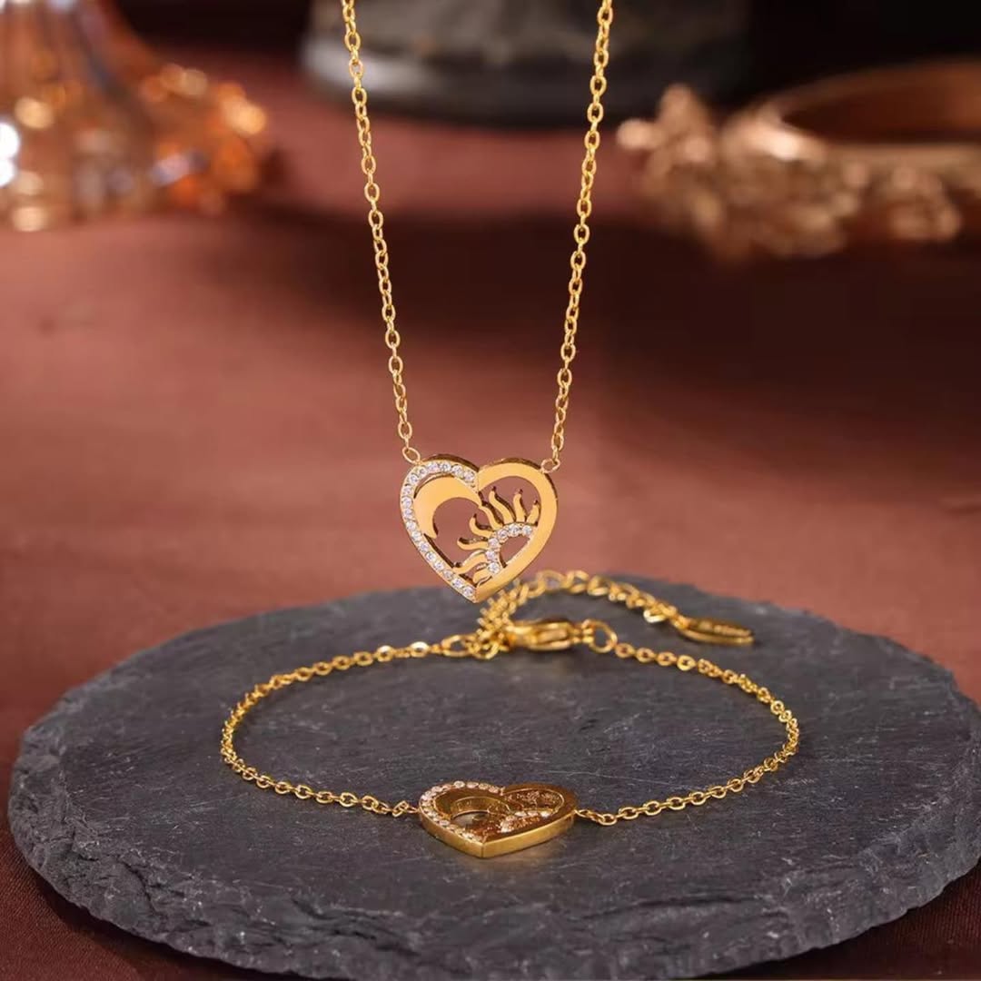 Gold heart-shaped necklace and bracelet on a dark stone surface with a brown background